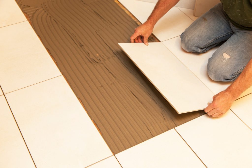 ceramic floor tiles into a bed of adhesive